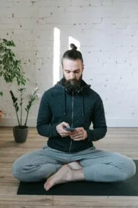 Man practicing mindfulness with a meditation app, symbolizing the use of digital tools for mental health improvement.